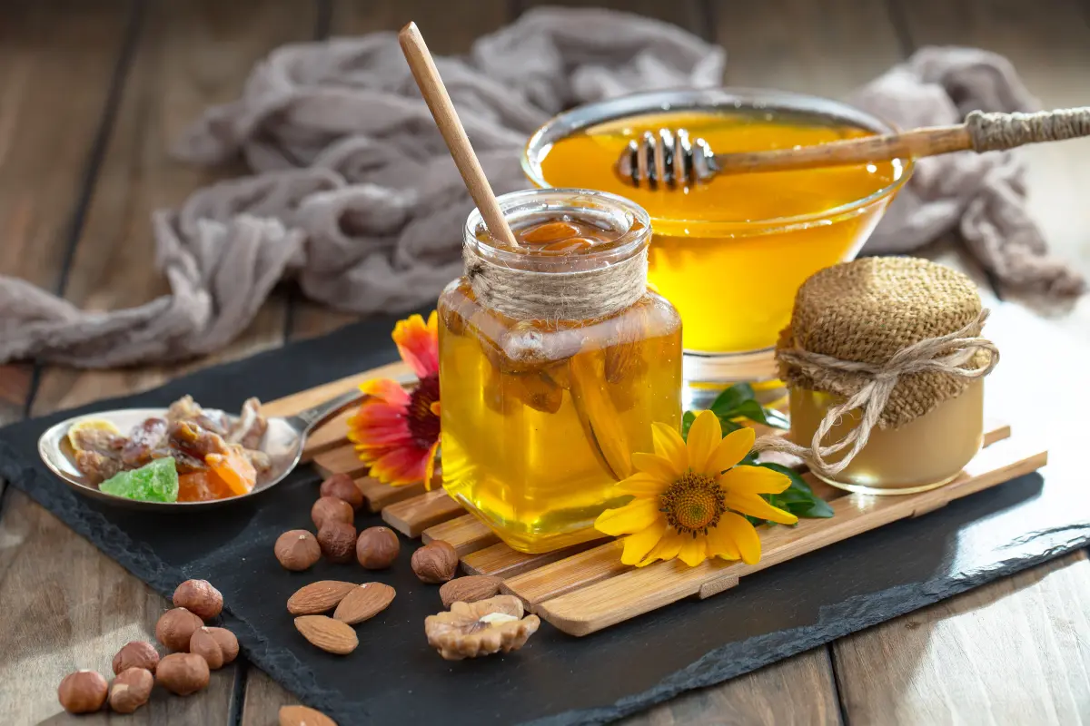 honige_glaeser_loeffel_nuesse_schiefertafel_tisch_blume honige_glaeser_loeffel_nuesse_schiefertafel_tisch_blume