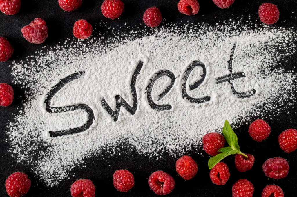 Wort süß ist auf einem dunklen Hintergrund neben Himbeerbeeren