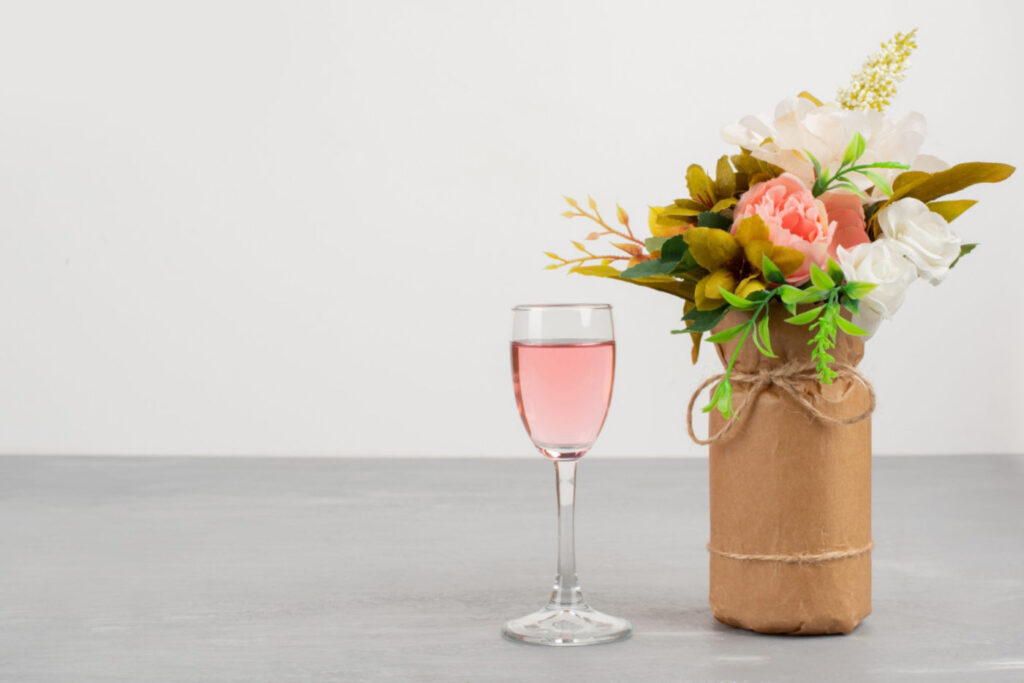 Ein Glas Rosé mit Blumenstrauß