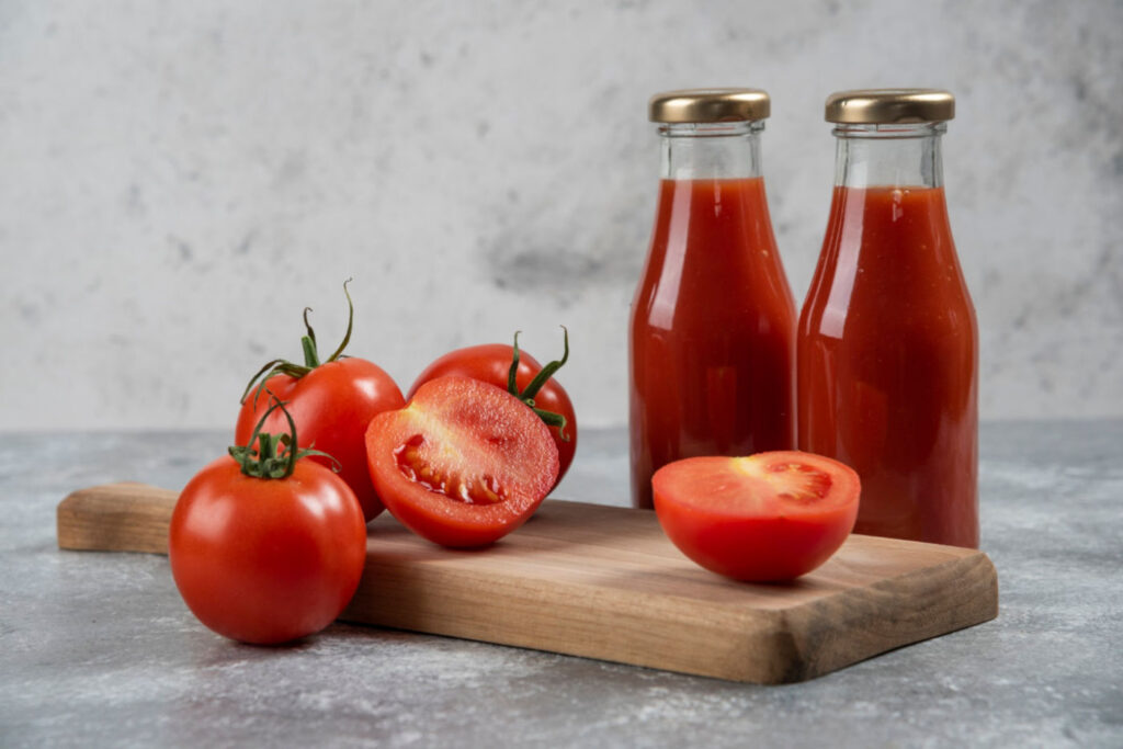 Tomatensaft in Gläsern auf einem Holzbrett