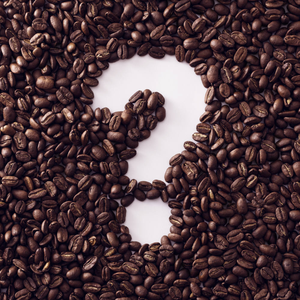 Fragezeichen umrahmt mit gerösteten frischen Kaffeebohnen