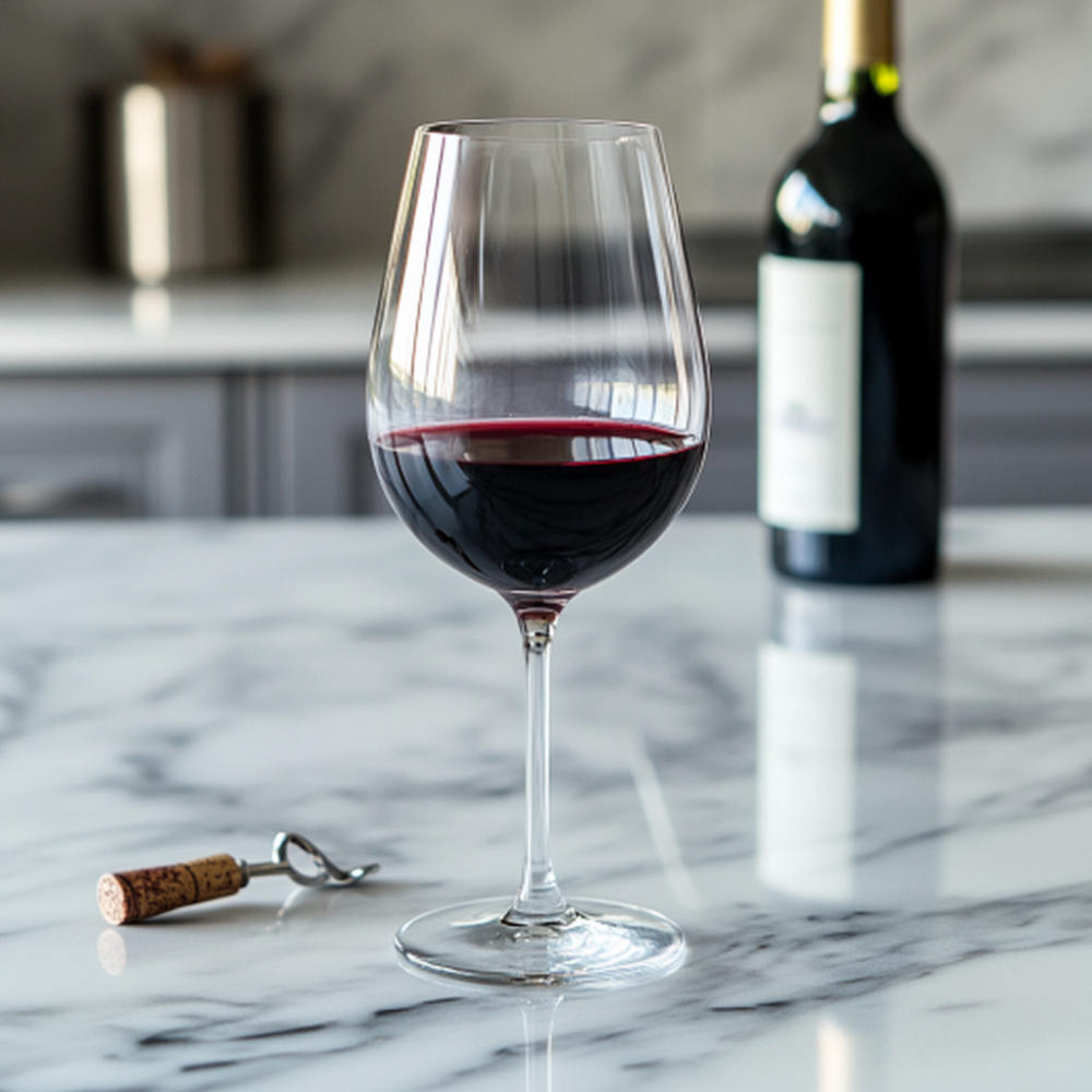 Ein Glas Rotwein und eine Flasche im Hintergrund